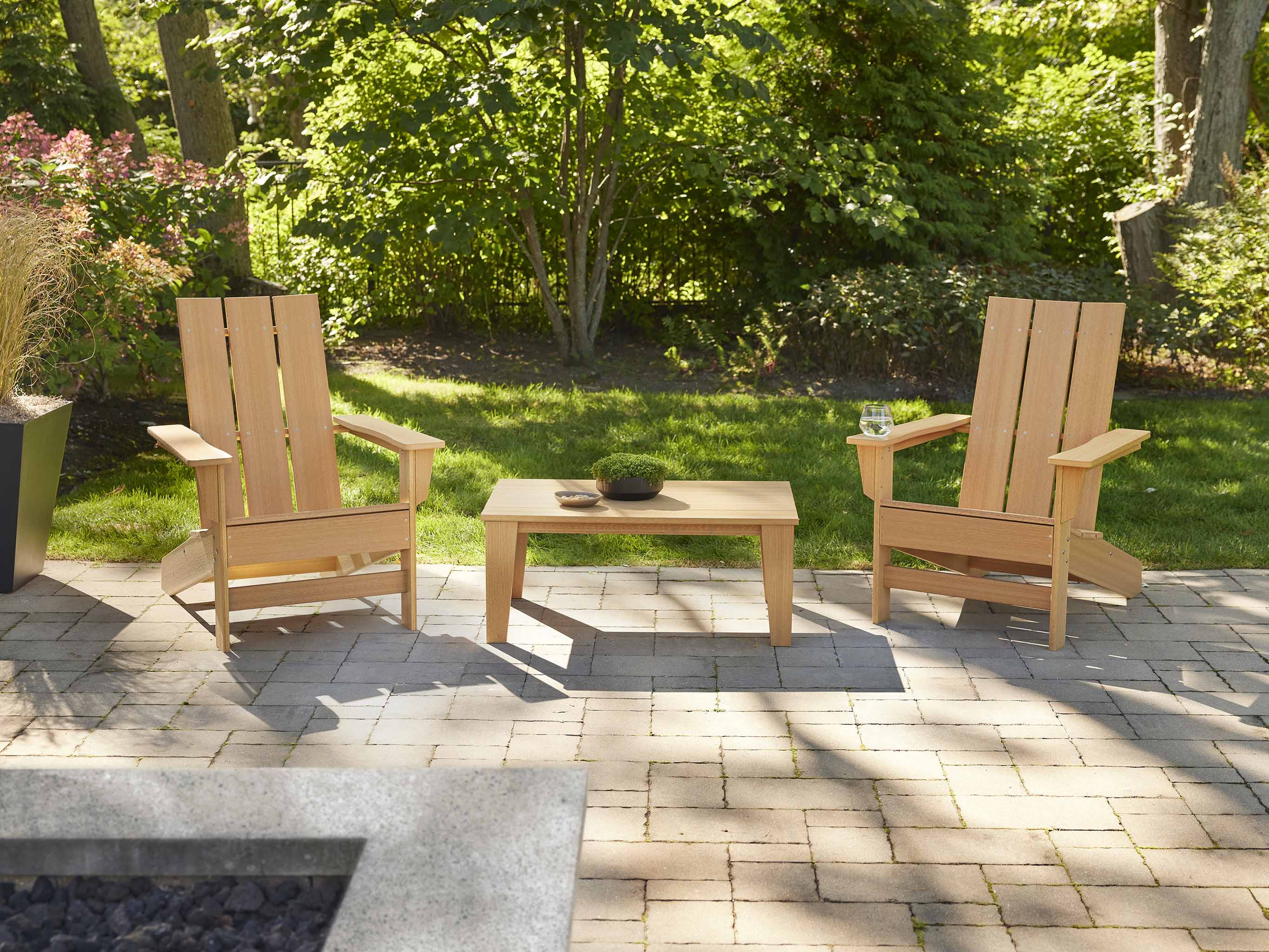 Two Aria Adirondack Chairs with Modern Coffee Table on a stone patio